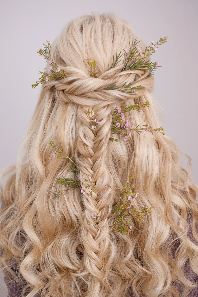 geflochtener fischgrätenzopf in halboffener frisur mit blumen geschmückt