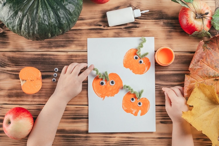 Grüne Pfeifenputzer um einen Kugelschreiber wickeln zum Formen und auf den Apfel kleben