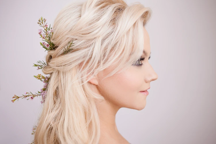 romantische halboffene flechtfrisur mit pony und zarten blüten im haar