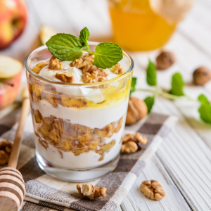 apfeldessert mit mascarpone, walnuss, zimt und honig in einem glasgefäß