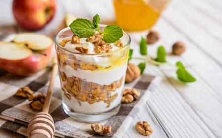 apfeldessert mit mascarpone, walnuss, zimt und honig in einem glasgefäß