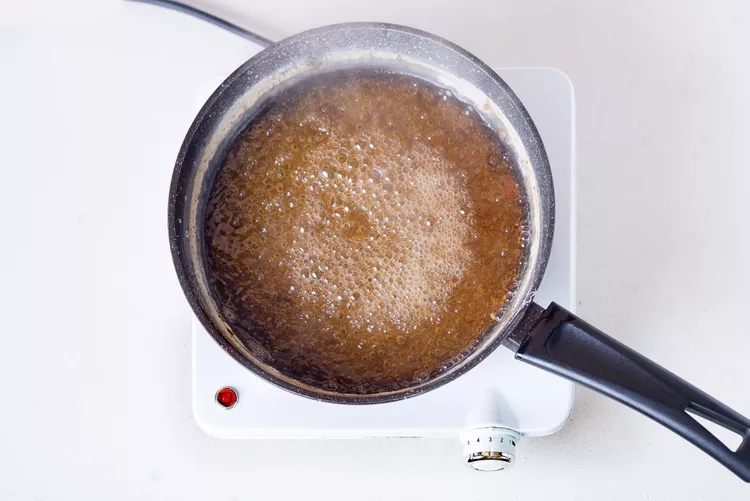 eine Reinigungslösung aus Backpulver und Wasser mit Tomatensaft zubereiten und nach Aufkochen Brandflecken im Topf entfernen