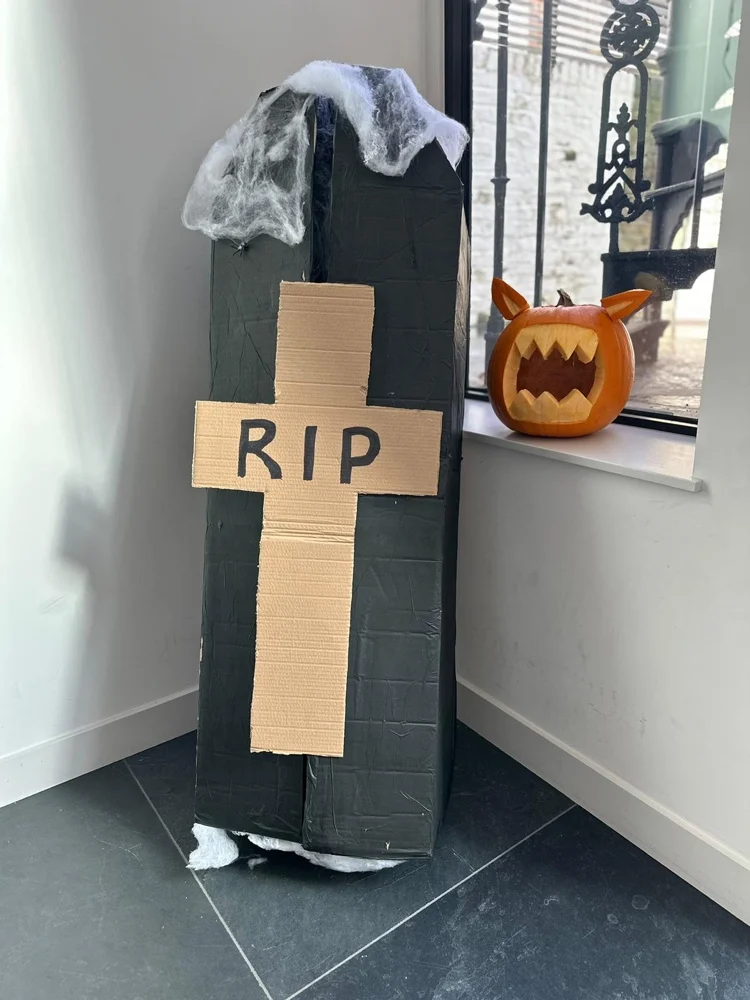 halloween deko für den flur mit sarg aus karton und geschnitztem kürbis