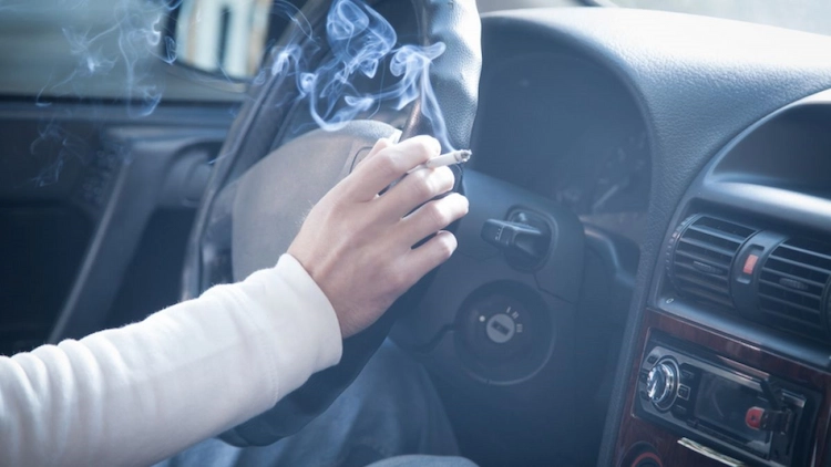 qualmende zigarette im kfz innenraum stört beifahrer und kann zu atemproblemen führen