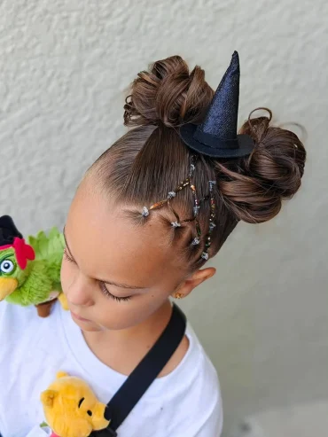Schöne Kinderfrisur mit Mini-Hexenhut als Haarschmuck