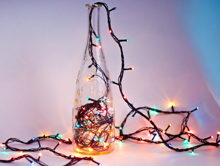 einfache glasflasche und bunte lichterkette als weihnachtsbeleuchtung