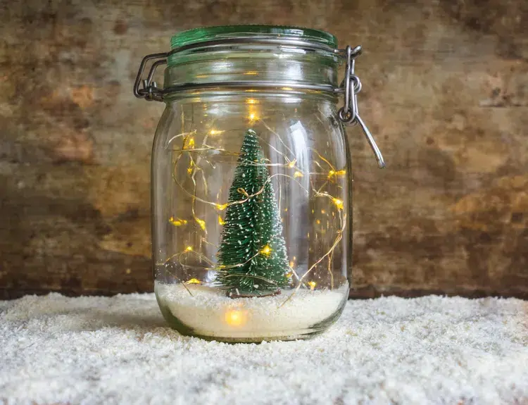 glas deko mit kunstschnee, lichterkette und weihnachtsbaum