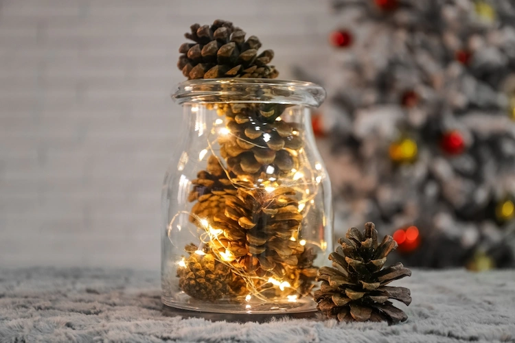 upcycling mit lichterketten, glas und tannenzapfen für weihnachtliche stimmung