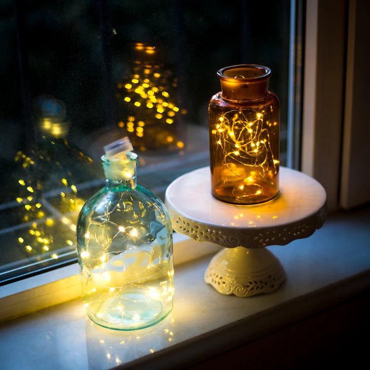 weihnachtliche fensterdeko mit lichterketten und gläsern