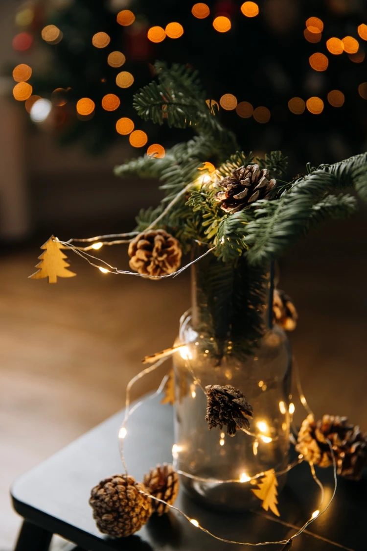 weihnachtsdeko im glas mit lichterkette und tannenzapfen