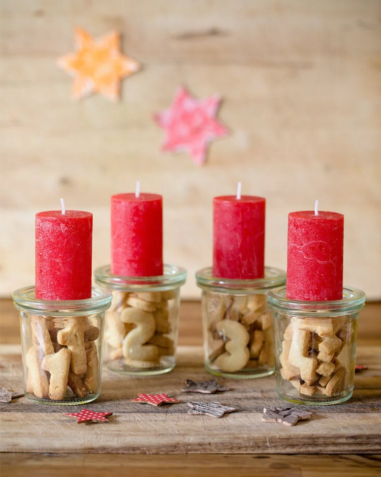 weihnachtsdekoration in gläsern als adventskranz mit kerzen und keksen