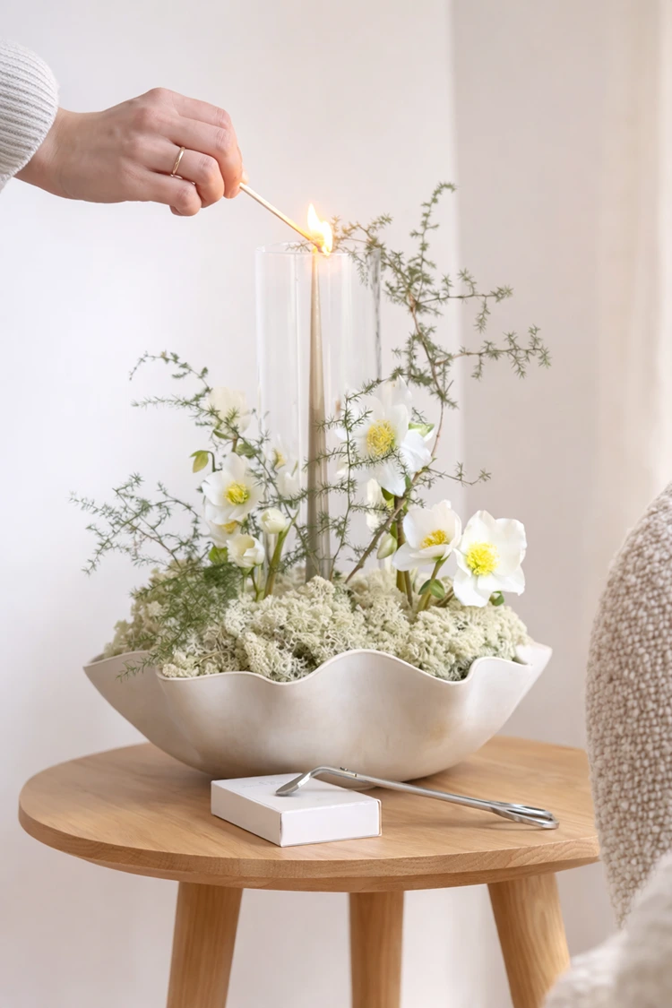 Deko mit Kerzen in einem minimalistischen Gesteck mit Christrosen