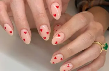 nudefarbene nägel mit winzigen roten herzen zum valentinstag 2024