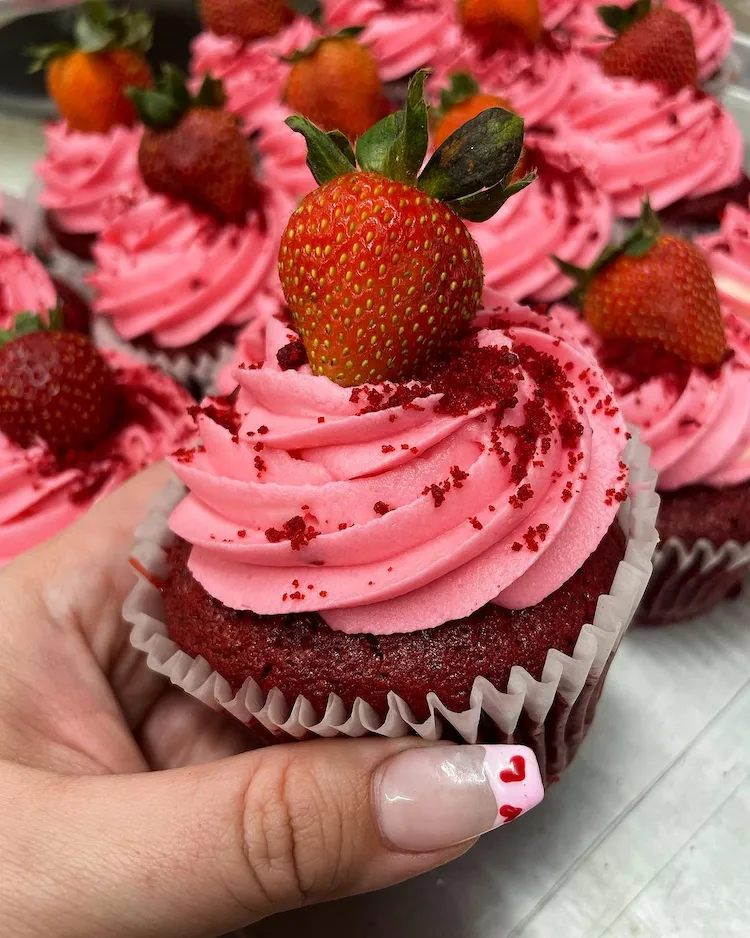 cupcakes mit rosafarbenem topping und erdbeeren
