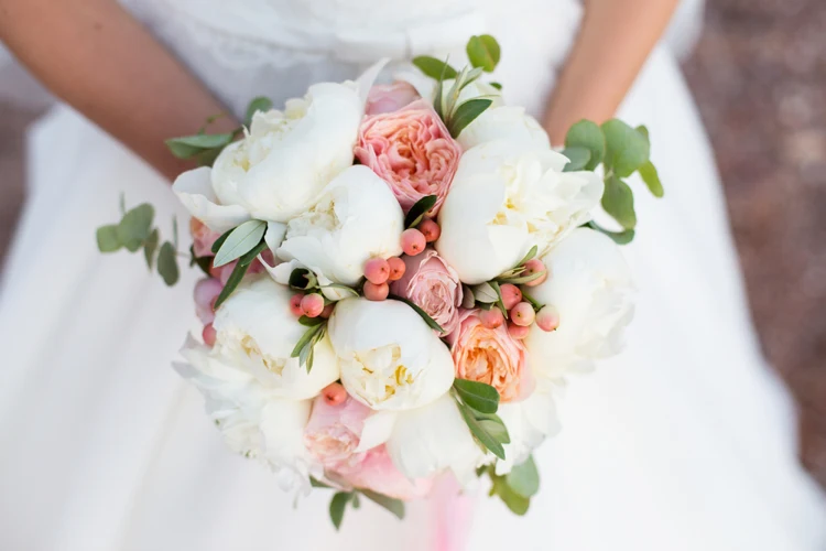 prächtiges bouquet aus weißen pfingstrosen, zarten pfirsichfarbenen rosen und kleinen beerenakzenten