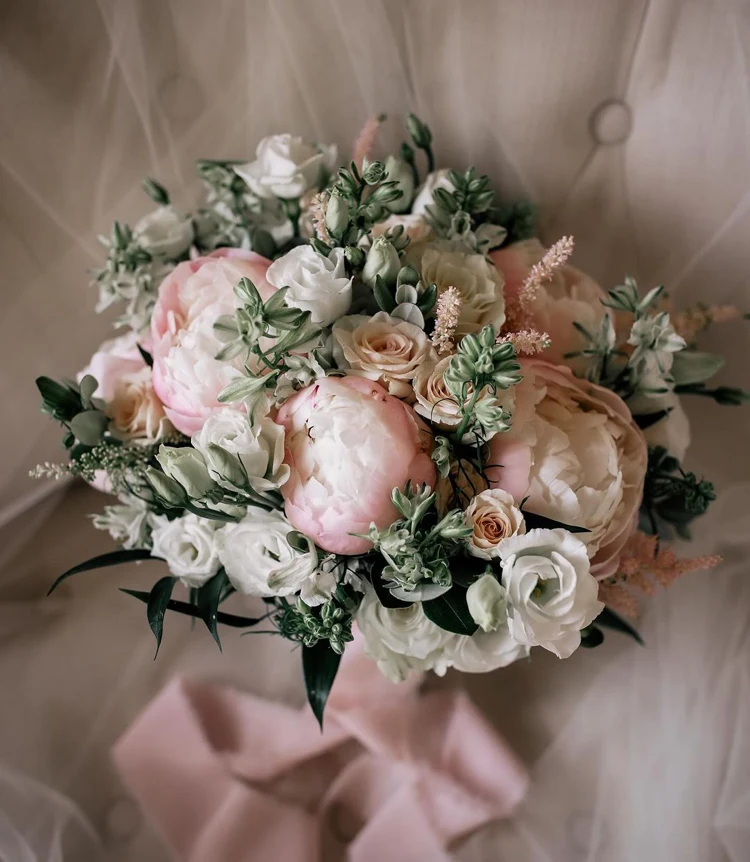 romantisches bouquet aus großen, zartrosa pfingstrosen und elfenbeinfarbenen rosen, akzentuiert mit feinen rosa blüten und grünem beiwerk