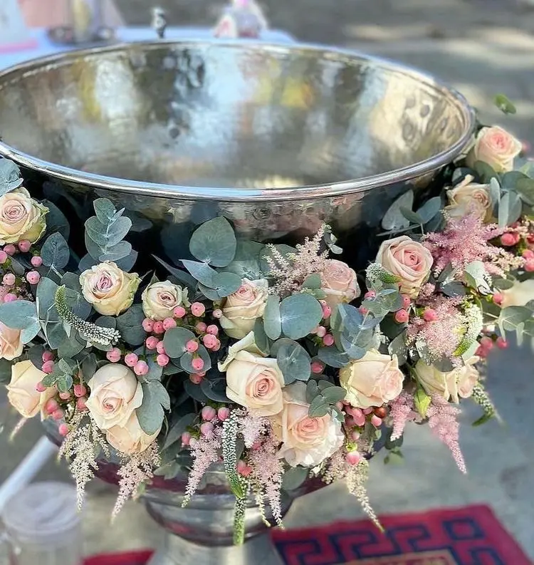 A baptismal font with floral decorations made of roses, astilbe and eucalyptus