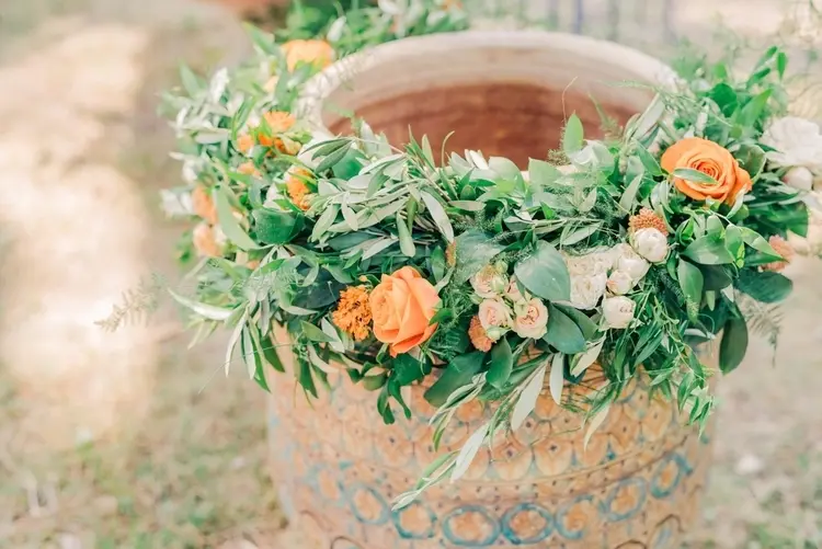 What are the soft orange baptismal flowers from roses and greenery from eucalyptus, olive or ivy