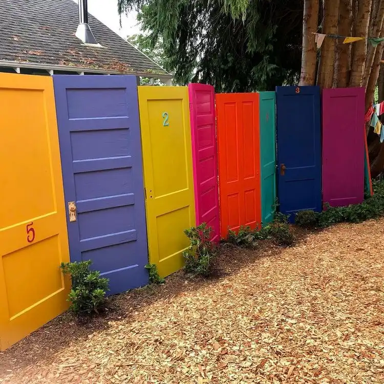 Alte Türen als Sichtschutz im Garten in bunten Farben