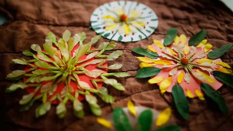 Kreise aus Papier ausschneiden und mit Blüten und Blättern gestalten