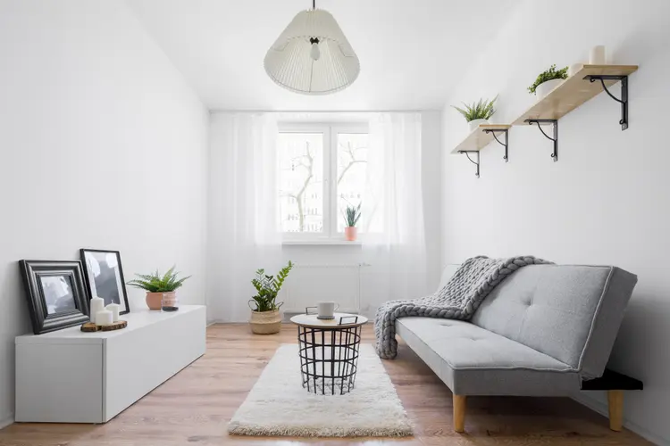 Langes, schmales Wohnzimmer einrichten im schlichten Scandi-Stil mit weißen Wänden