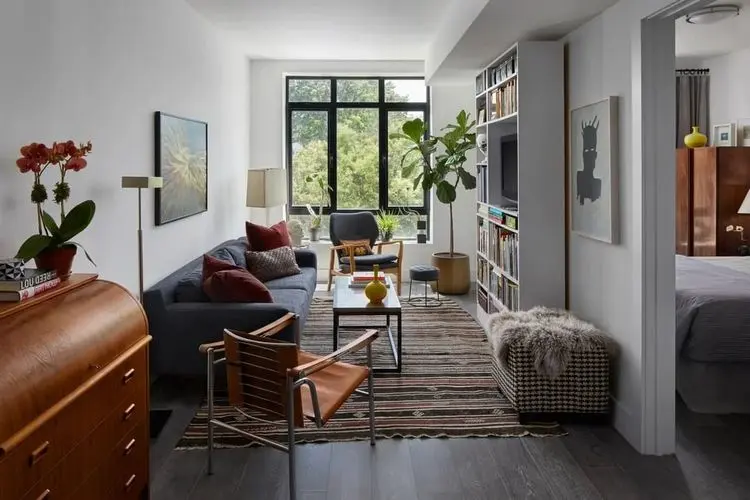 Schmales Wohnzimmer einrichten mit Wandregal, Sofa und Teppich