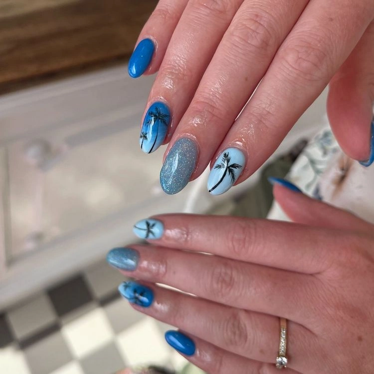 Blaue Fingernägel mit Glitzer und Palmenmotiven dekorieren