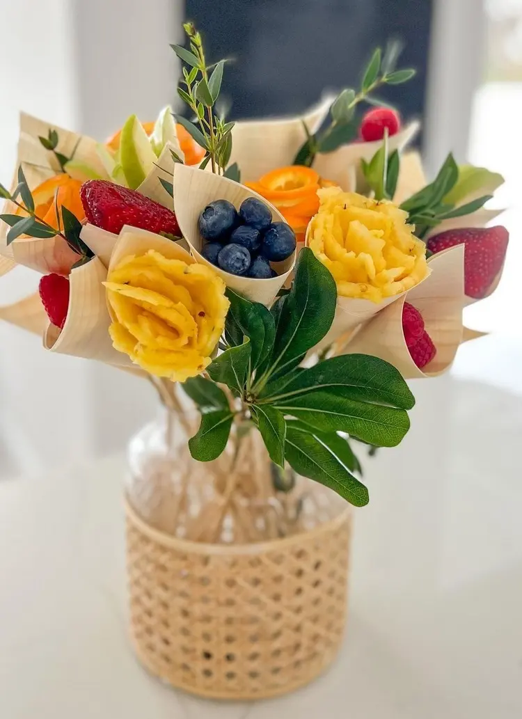Essbarer Blumenstrauß mit Fingerfood - Obst kleinschneiden und in Papiertrichtern mit Spießen servieren