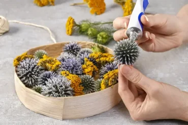 Blüten in der Box anordnen und festkleben für ein Faux-Blumengesteck