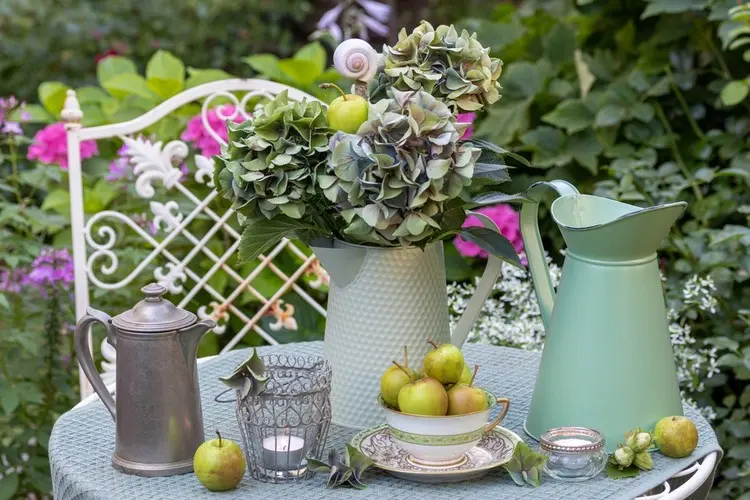 Arrangement in Pastellgrün mit Äpfeln und Hortensien