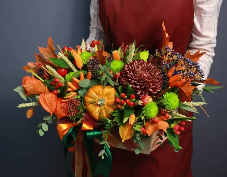 Buntes Herbstgesteck mit Kürbissen, Dahlien und anderen Herbstblumen