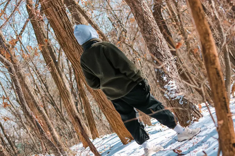 dunkle fleecejacke und jogginghose im verschneiten wald