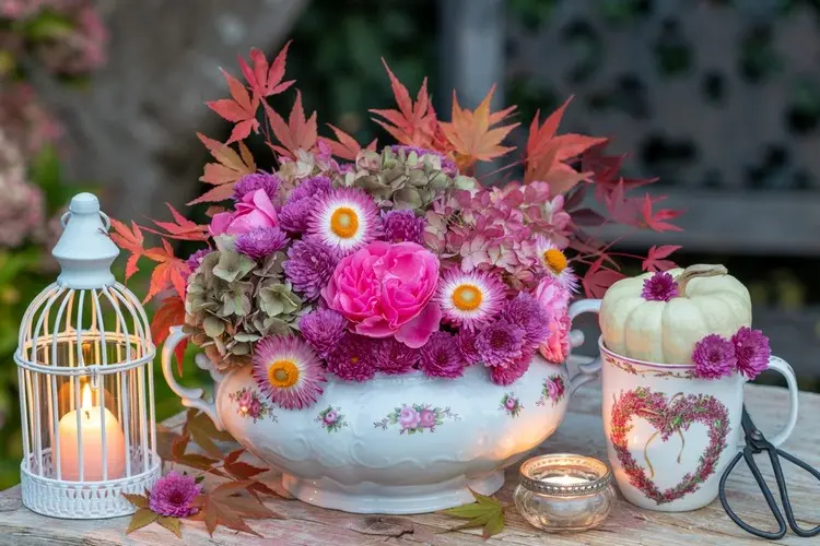 Gesteck in Porzellanvase als Deko für den Gartentisch im Herbst