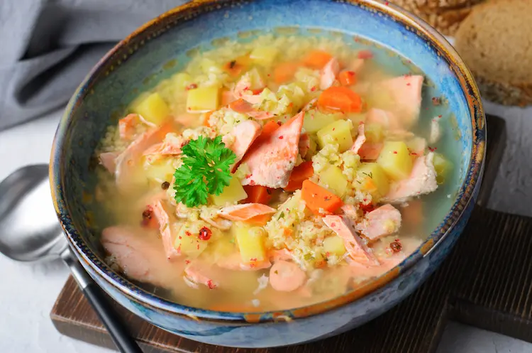 hausgemachte hirsesuppe mit zartem lachs, kartoffeln und karotten