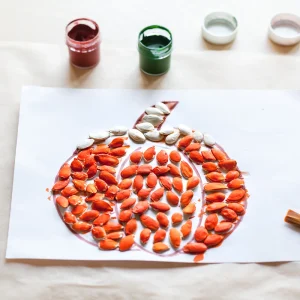 Kürbis basteln mit Kürbiskernen als Idee für Kinder
