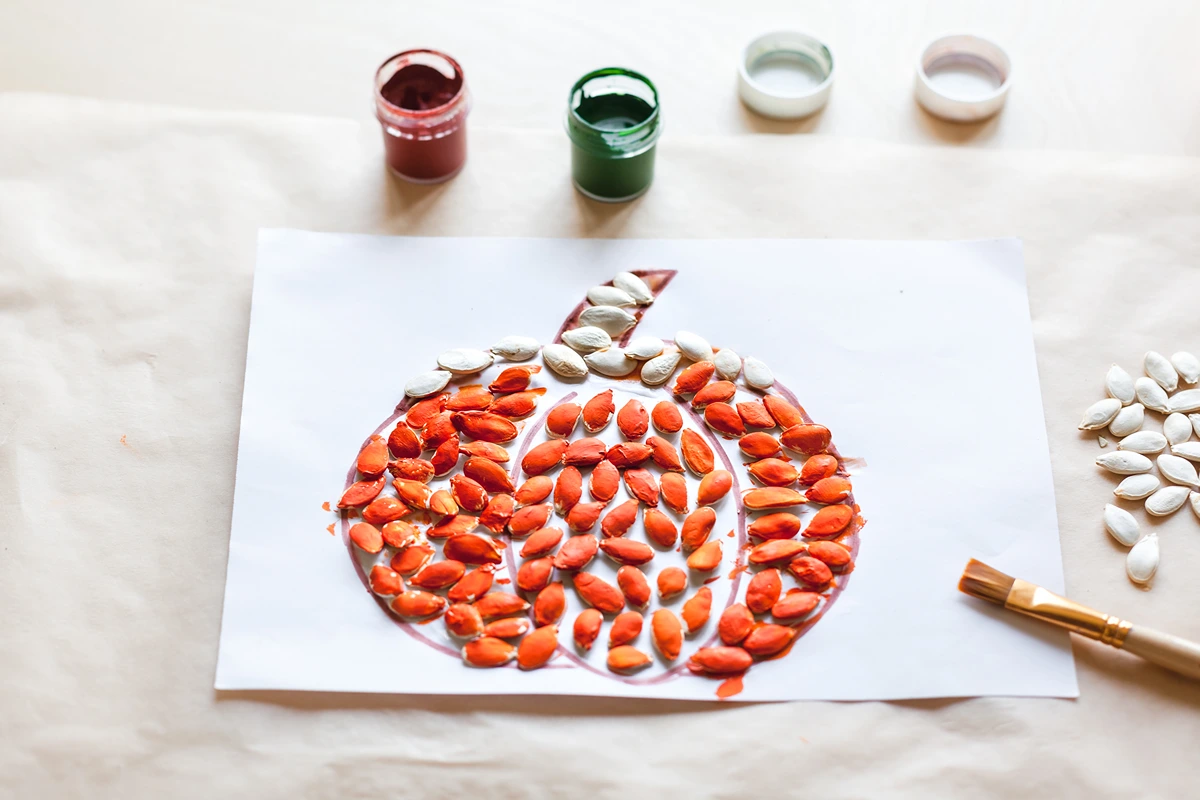 Kürbis basteln mit Kürbiskernen als Idee für Kinder