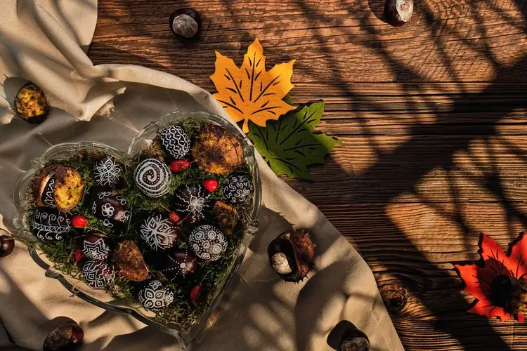 Muster auf Kastanien malen mit Kreidestiften und in einer Schale als Herbstdeko präsentieren