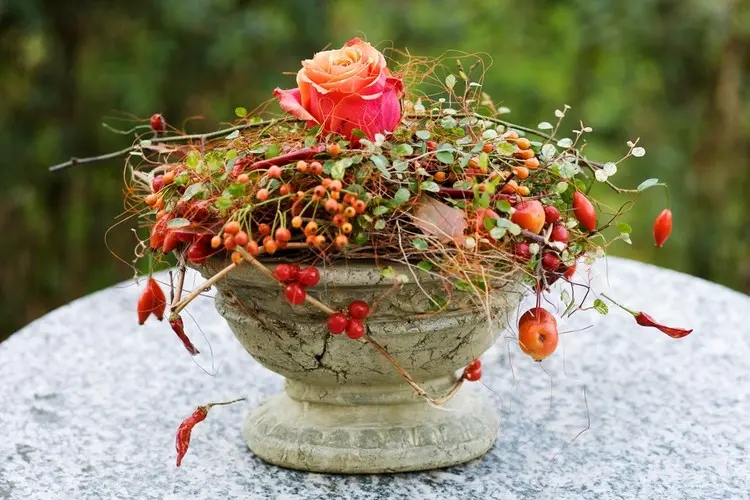 Alternative zur Bepflanzung - Kranz aus Zweigen und Beeren mit Rose auf eine Schale legen