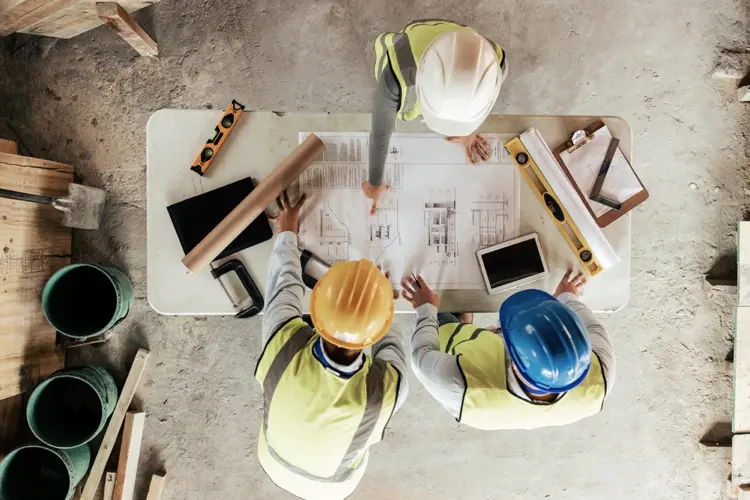 bauplanung vor ort – bauleiter und handwerker bei der arbeit