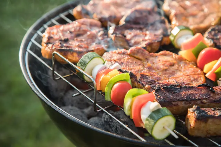 bunte gemüse und fleischspieße auf einem klassischen holzkohlegrill