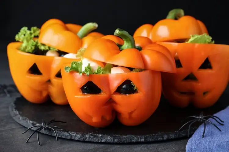 Coole Gemüseplatte für Halloween anrichten mit orangen Paprikaschoten in Kürbis-Optik