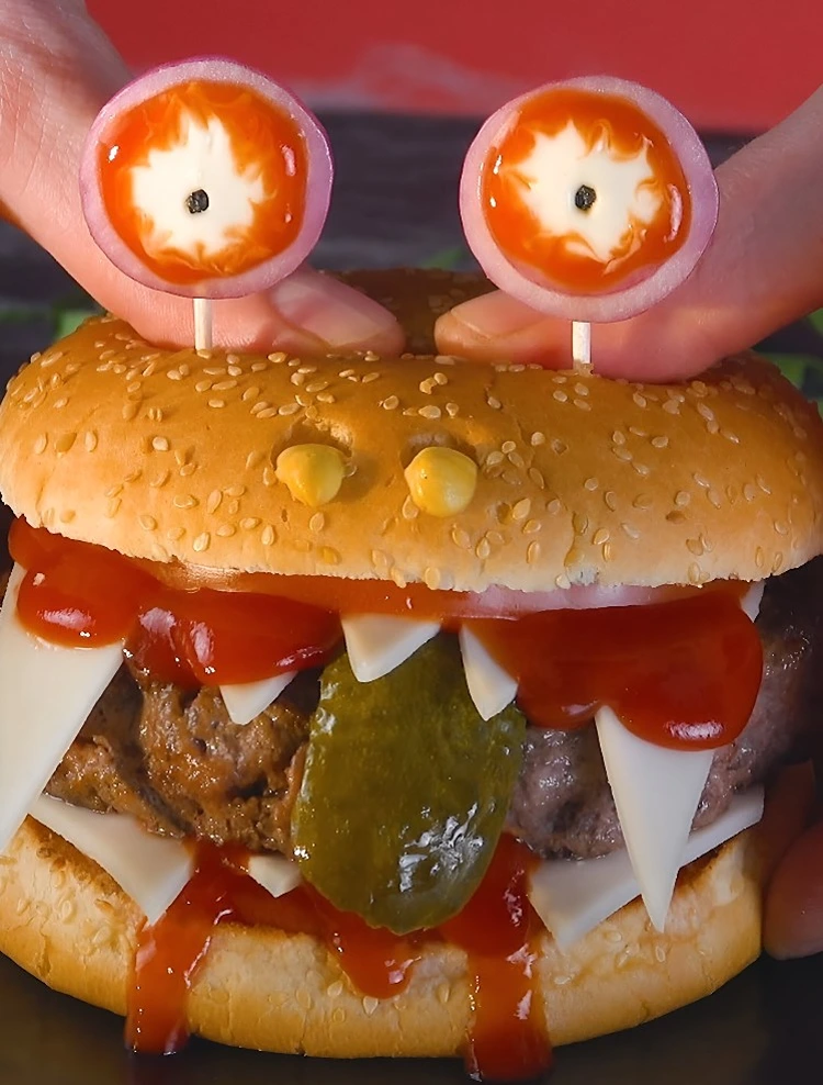 Cooles Monster mit Käsescheibe für Zähne und Augen aus Zwiebelringen, Tomate und Mozzarella