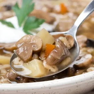 Die Herbstsuppe mit Graupen kann mit Sauerrahm serviert werden