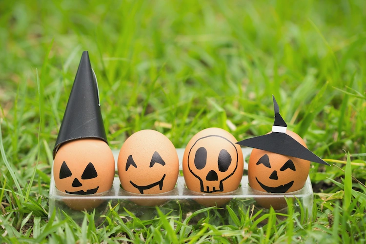 eier zu halloween mit schwarzem marker dekorieren