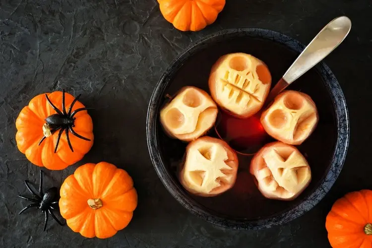 Getränke für Halloween mit geschnitzten Äpfeln servieren