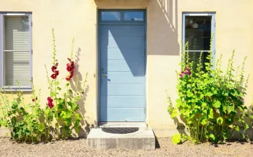 haus in schweden mit blauer haustür nach außen öffnend