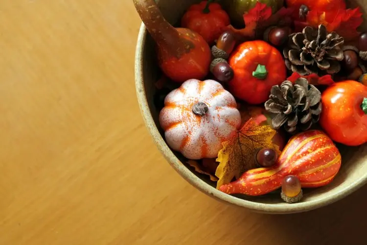 Hölzerne Schale herbstlich dekorieren in bunten Herbstfarben in Kürbissen