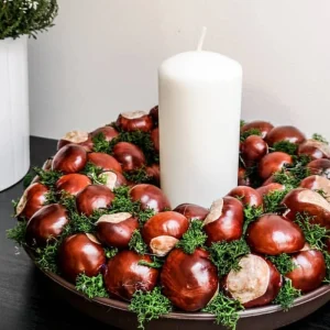 kastanienkerz und weiße große kerze herbstliche deko