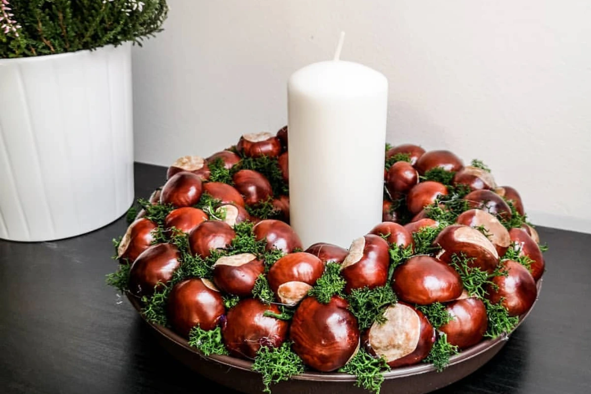 kastanienkerz und weiße große kerze herbstliche deko