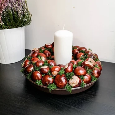 kastanienkerz und weiße große kerze herbstliche deko